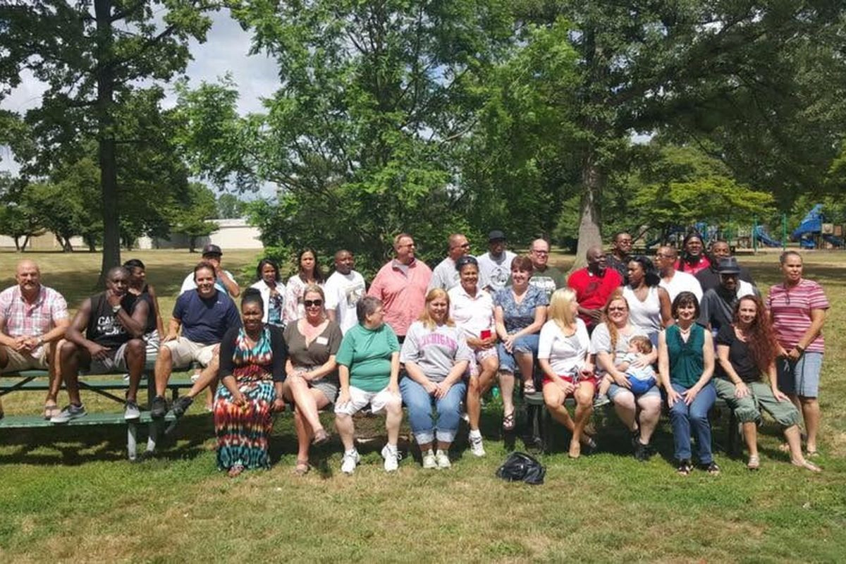 Large group of classmates gathered outdoors at a park reunion picnic