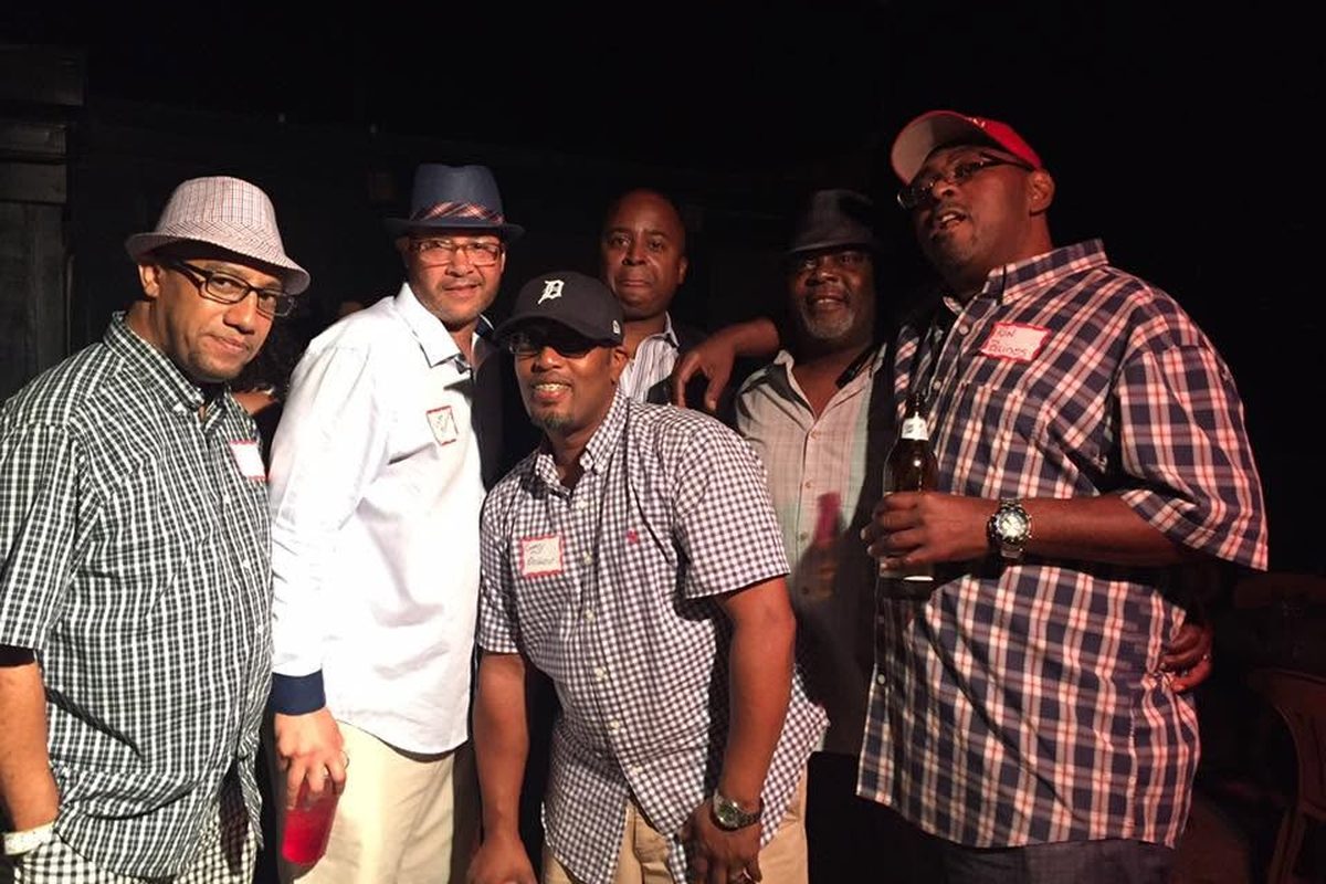 Classmates smiling together at an indoor Big Reds reunion gathering