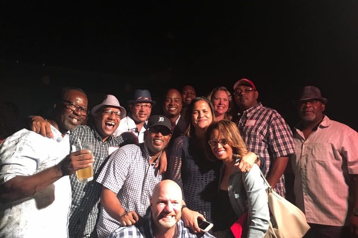 Classmates smiling together at a nighttime Big Reds reunion gathering